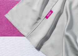 The top sheet of Juno Bamboo Sheets - showing the berry-coloured Juno brand tag