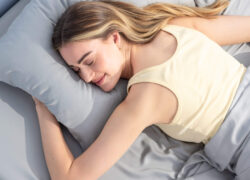 Woman sleeping on her stomach on a mattress fitted with Juno Bamboo Sheets