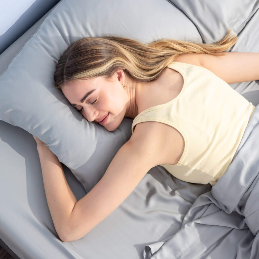 Woman sleeping on her stomach on a mattress fitted with Juno Bamboo Sheets