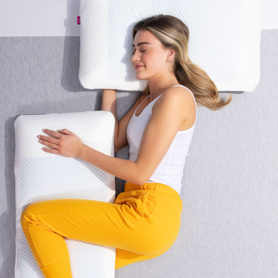 Woman sleeping on her side, hugging her Juno Cooling Gel Pillows