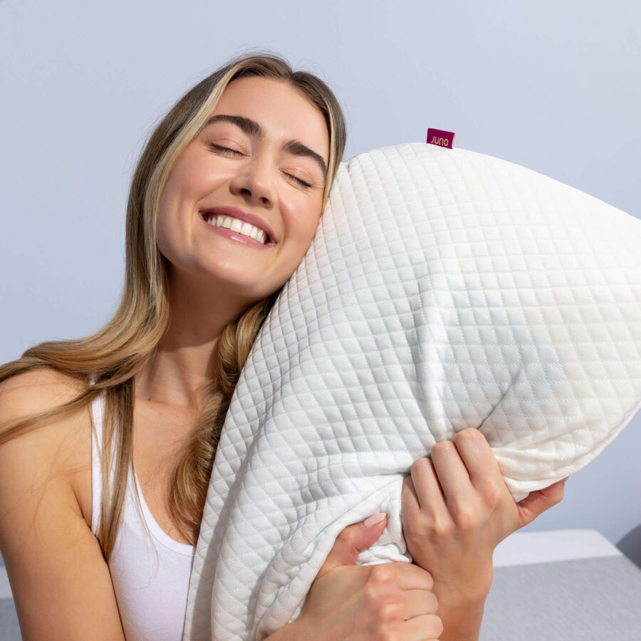 Woman smiling and hugging her Juno Cooling Gel Pillow
