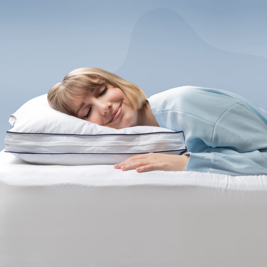 DB-MemoryFoamPillow-Carousel-7_-900x900-FR Une femme sourit en posant sa tête sur un oreiller ajustable en mousse mémoire Juno.