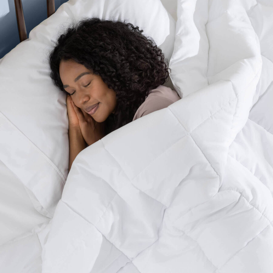 Woman sleeping peacefully, covered with a Juno Down Alternative Duvet
