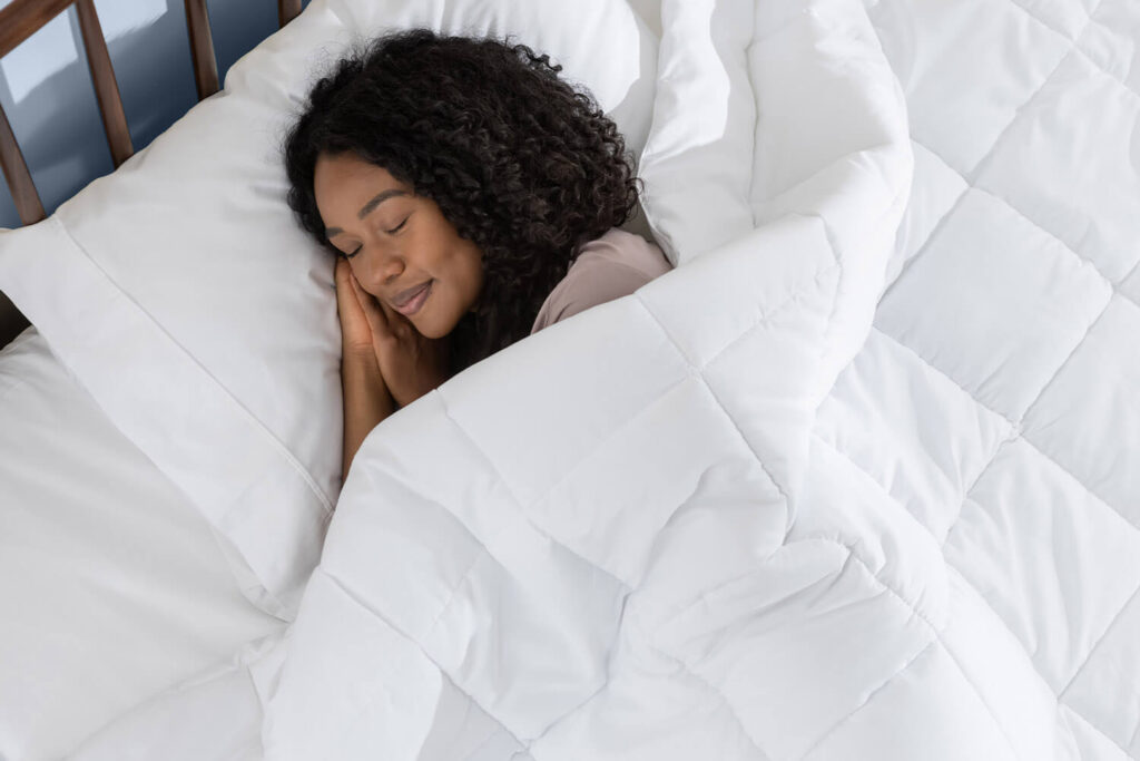 Woman sleeping peacefully, covered in a Juno Down Alternative Duvet