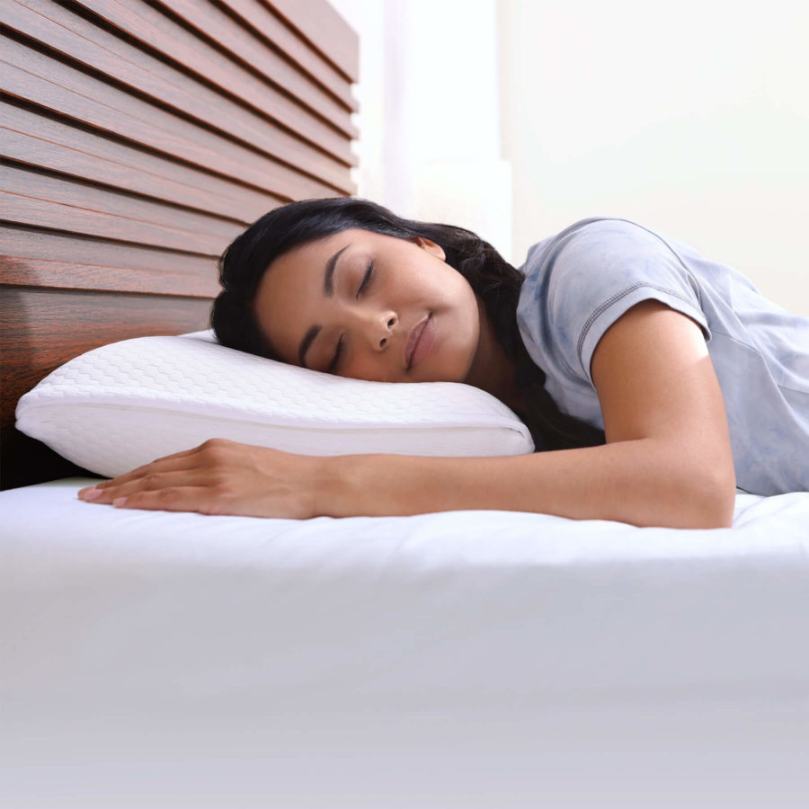 Une femme repose sa tête sur un oreiller en mousse mémoire avec gel rafraîchissant Juno.