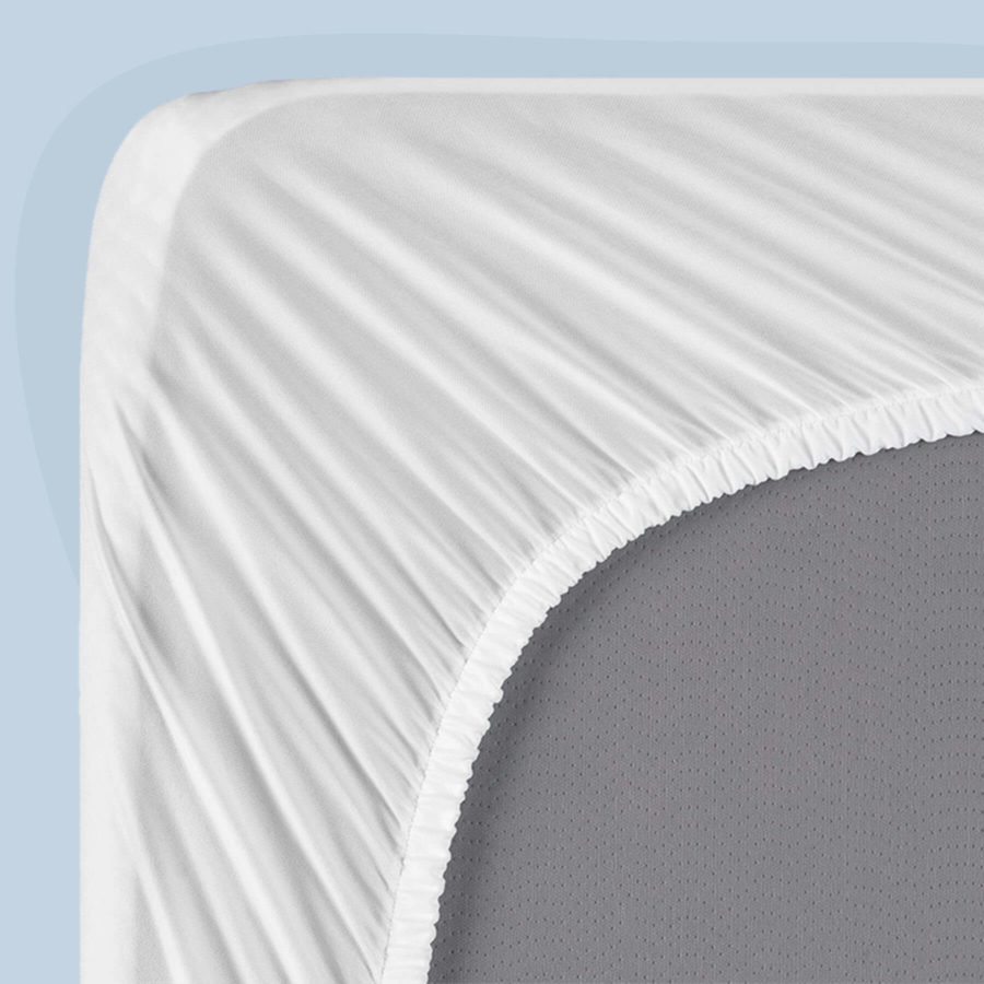 A bottom-corner view of a Juno mattress protector, showing the stretchable elastic snugly fit over a Juno mattress.