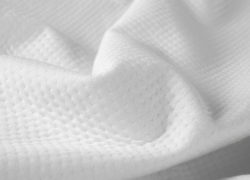 Une vue rapprochée qui montre le motif alvéolé sur le protège-matelas Juno.