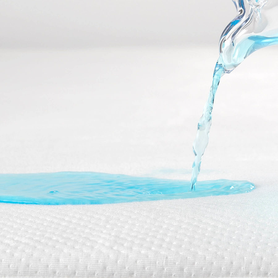 Blue liquid is poured onto the Juno mattress protector to show it's protective and absorbent qualities.