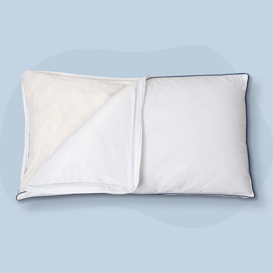 A Juno Adjustable Memory Foam Pillow with a corner of the pillow unzipped and exposed showing the fill within.