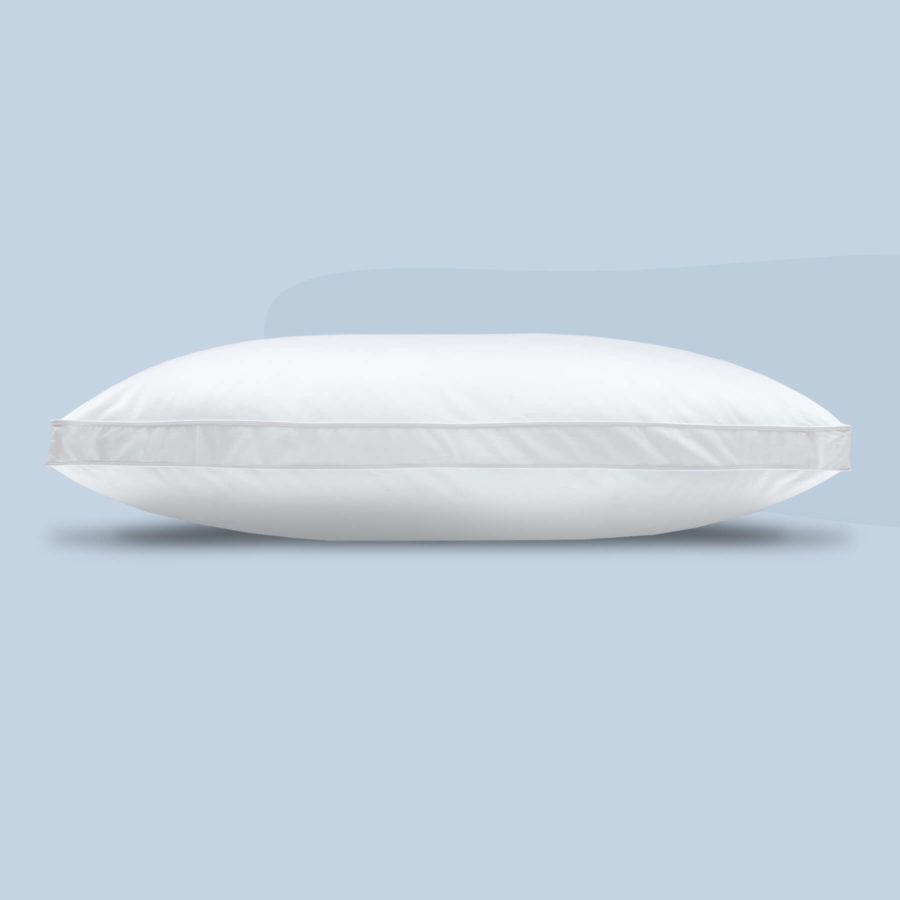 A side profile view of the Juno microfibre pillow against a light blue background.