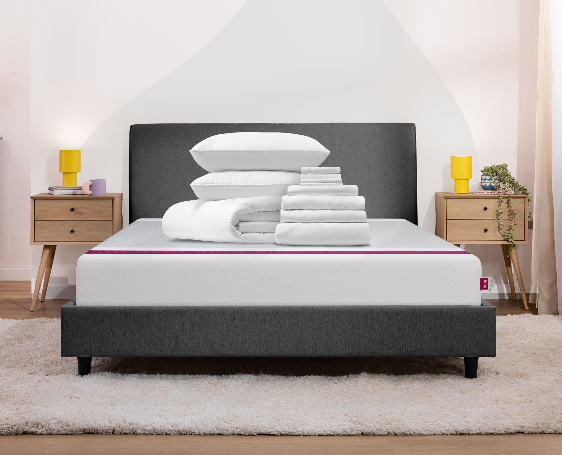 A sleep bundle sits neatly folded on a Juno Mattress.