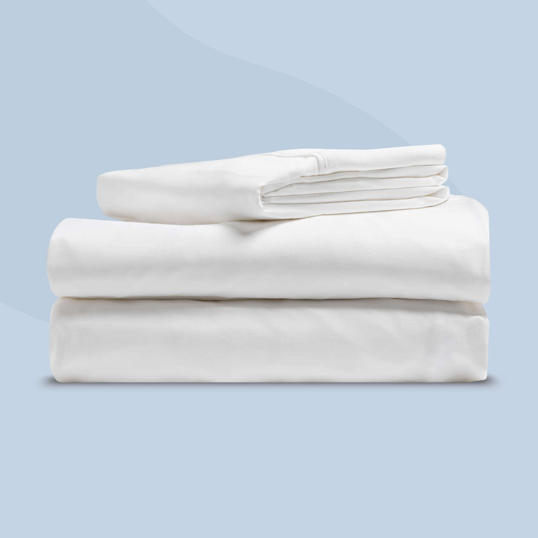 JB-SheetSet-Carousel-1-FR Un drap de dessus, un drap-housse et une taie d'oreiller sont soigneusement pliés sur un fond bleu clair.