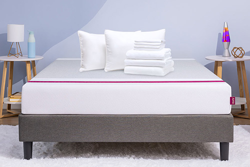 A series of bedding items and pillows lay on top of a Juno mattress for the Build a Bundle promotion. 