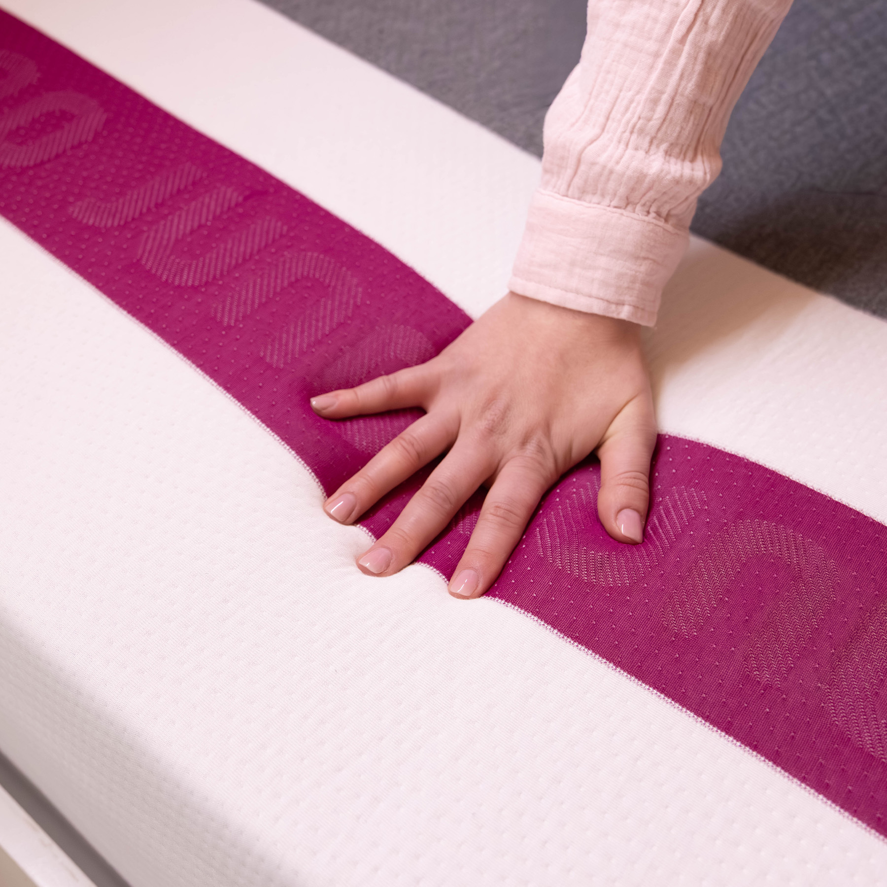 Hand pressing into the cover of a Juno RV hybrid mattress