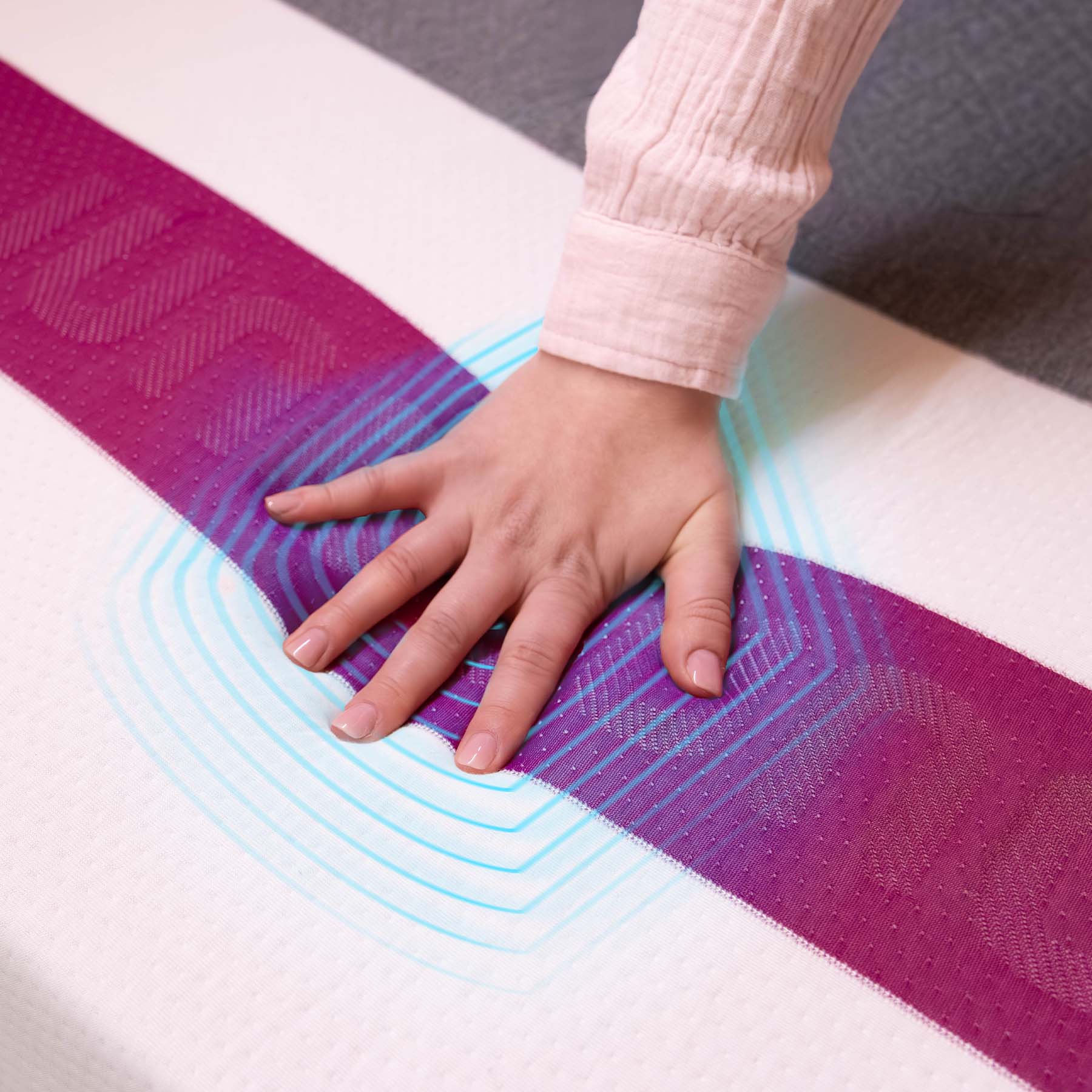 Woman's hand pressing into the cooling top cover of a Juno RV hybrid Cool+ mattress