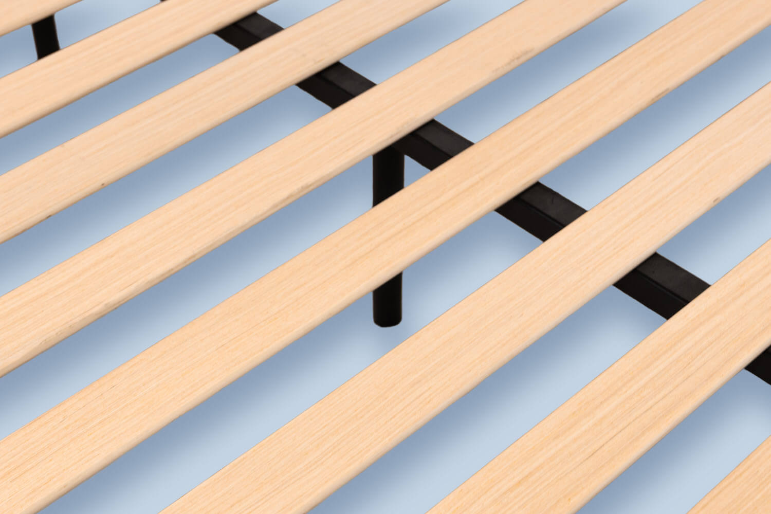 Vue détaillée des lattes de bois et de la poutre centrale en acier de la base de lit plateforme.