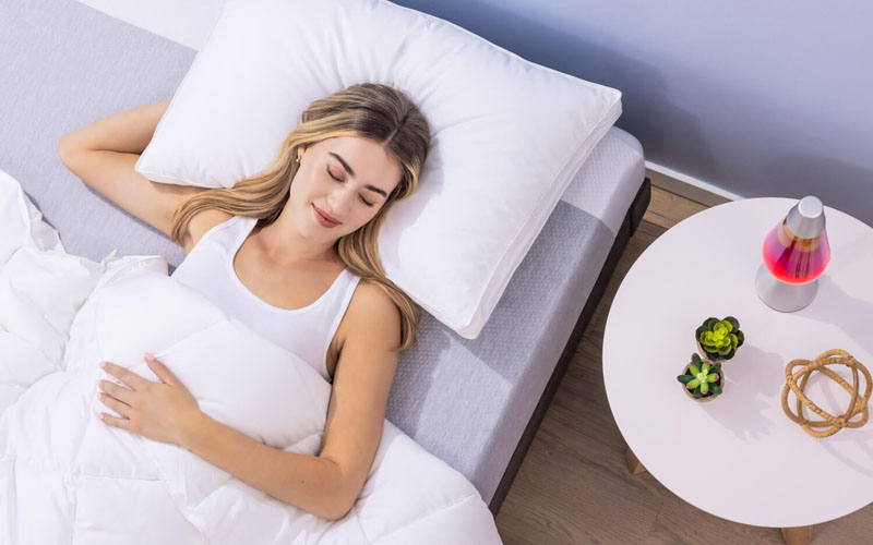 Woman sleeping peacefully on her back on a Juno mattress