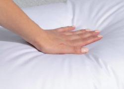 Hand pressing into a Juno Down Alternative Pillow