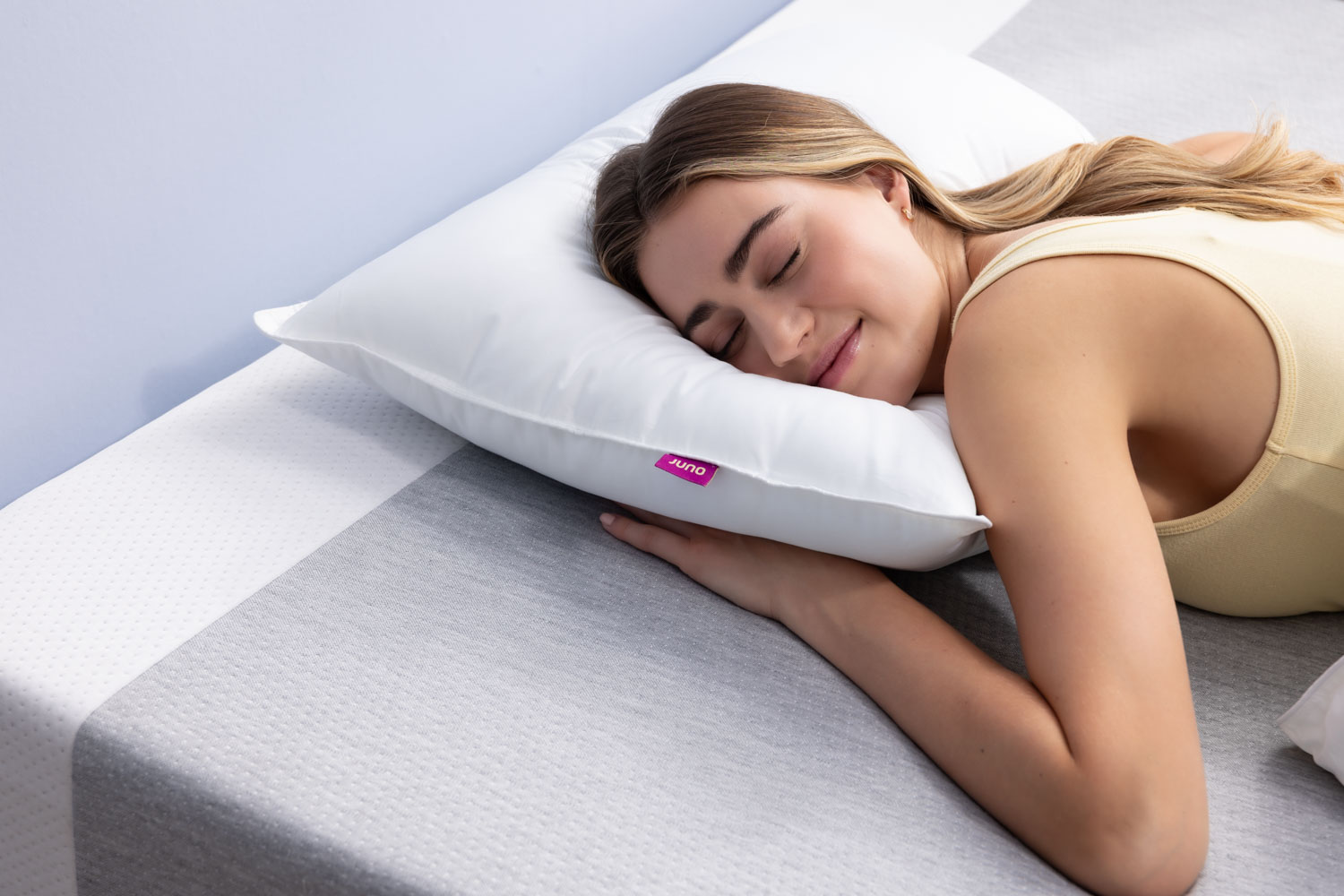 Femme dormant sur le ventre avec un oreiller Juno en duvet synthétique