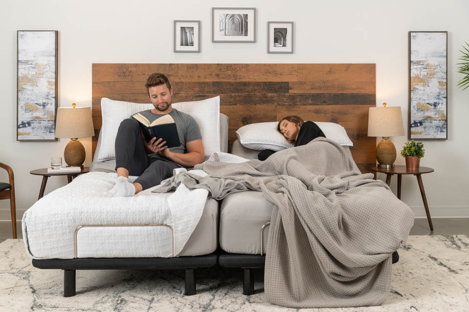 Un homme lit pendant qu’une femme se repose dans leur lit ajustable Podium.